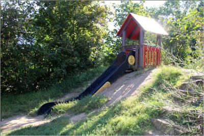 Holzhaus und Rutsche auf einem Hügel