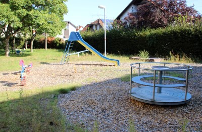 Drehkarussell im Vordergrund, Rutsche im Hintergrund