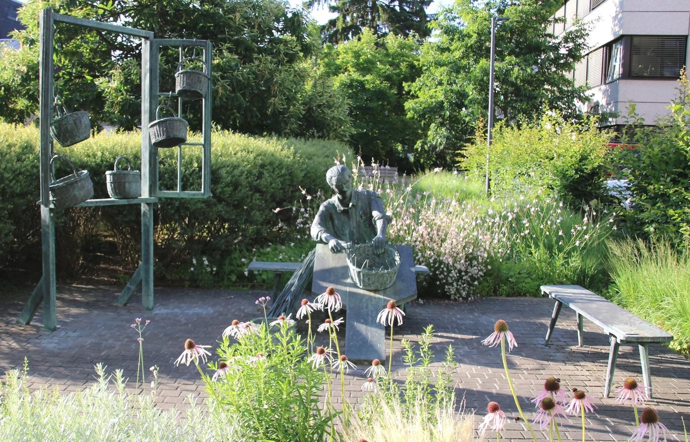 das Denkmal zeigt einen Korbmacher beim Flechten von Körben