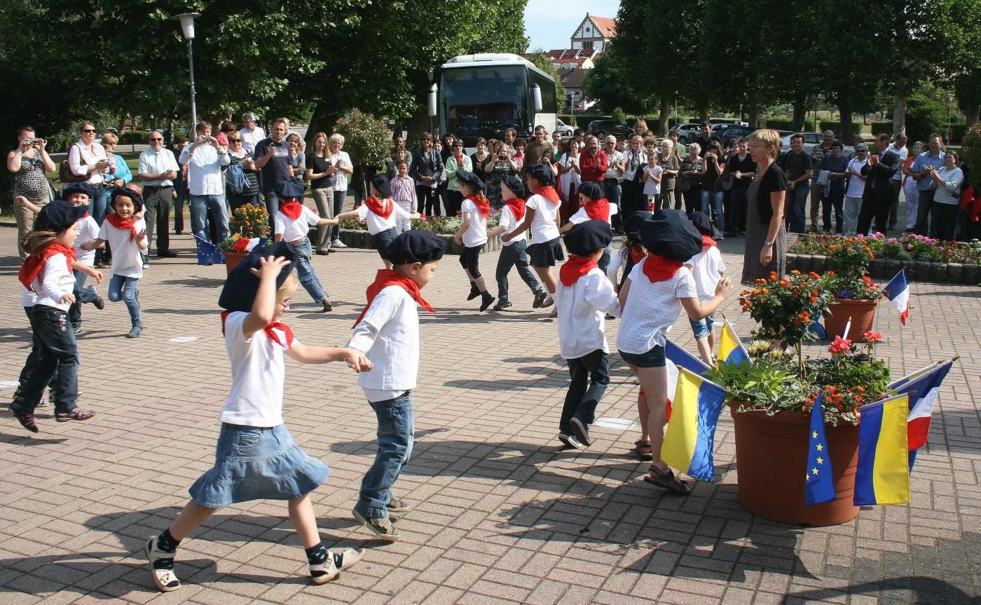 Das Bild zeigt die Begrüßung der französischen Gäste mit einer Tanz-Aufführung des Johanneskindergartens