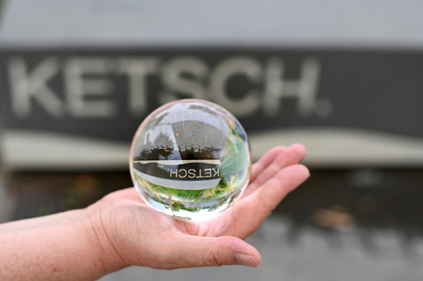 Schriftzug Ketsch spiegelt sich in einer Glaskugel