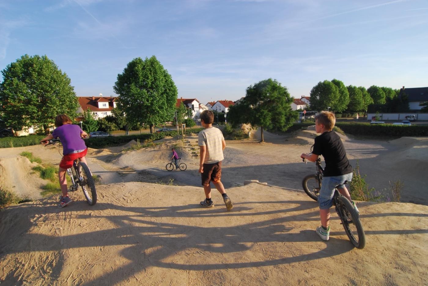 Kinder mit BMX-Rädern auf einem Sandhügel
