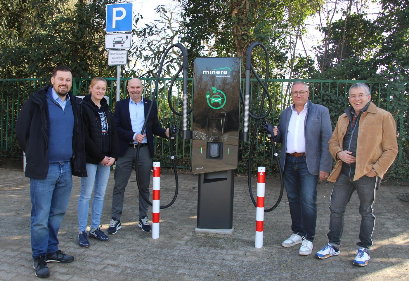 Neue Ladesäule und Verwaltungsmitglieder und Minera-Mitarbeiter