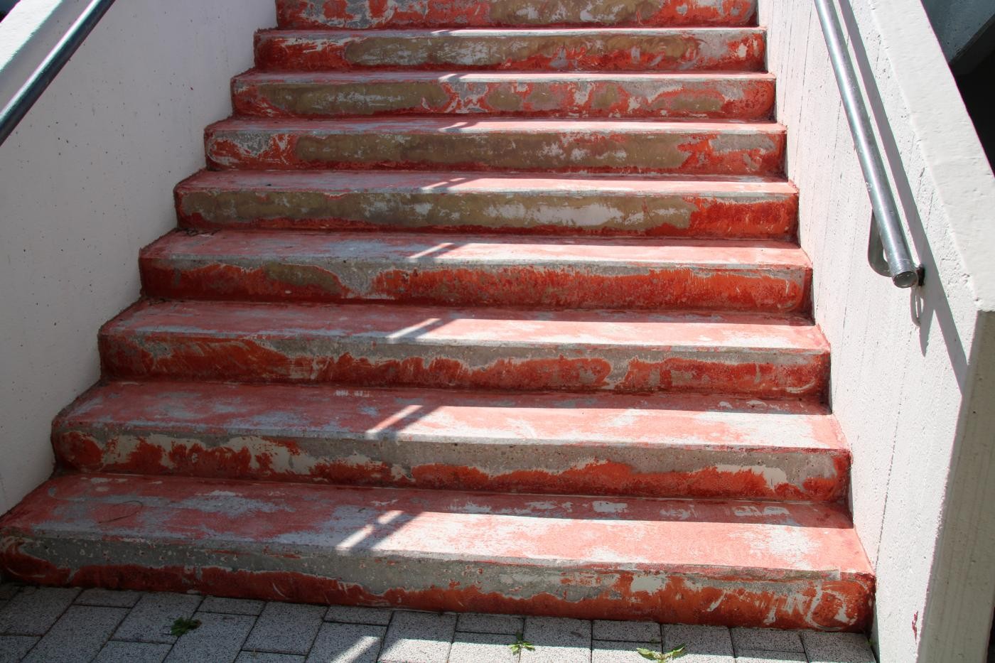 Treppenstufen, auf denen die alte rote Farbe entfernt wurde