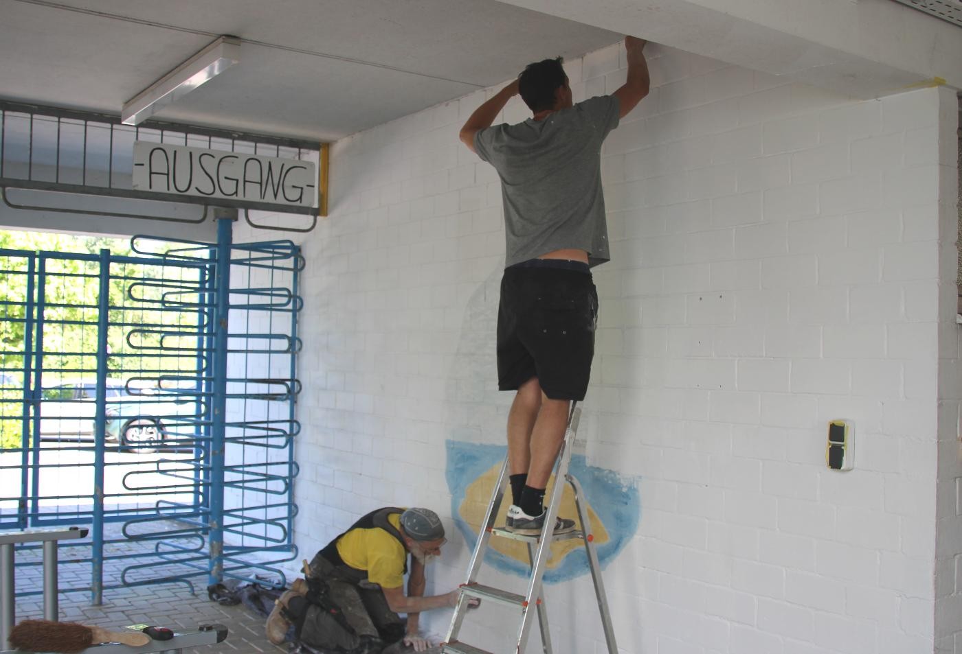 zwei Männer streichen eine Wand