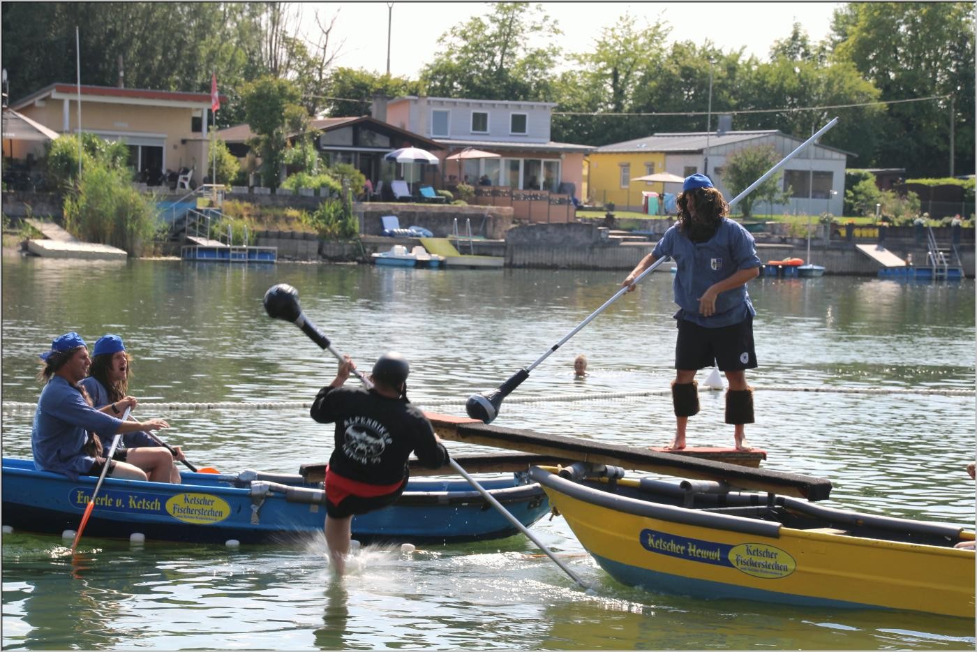 Zwei Boote mit den Stechern, wobei ein Stecher ins Wasser stürzt