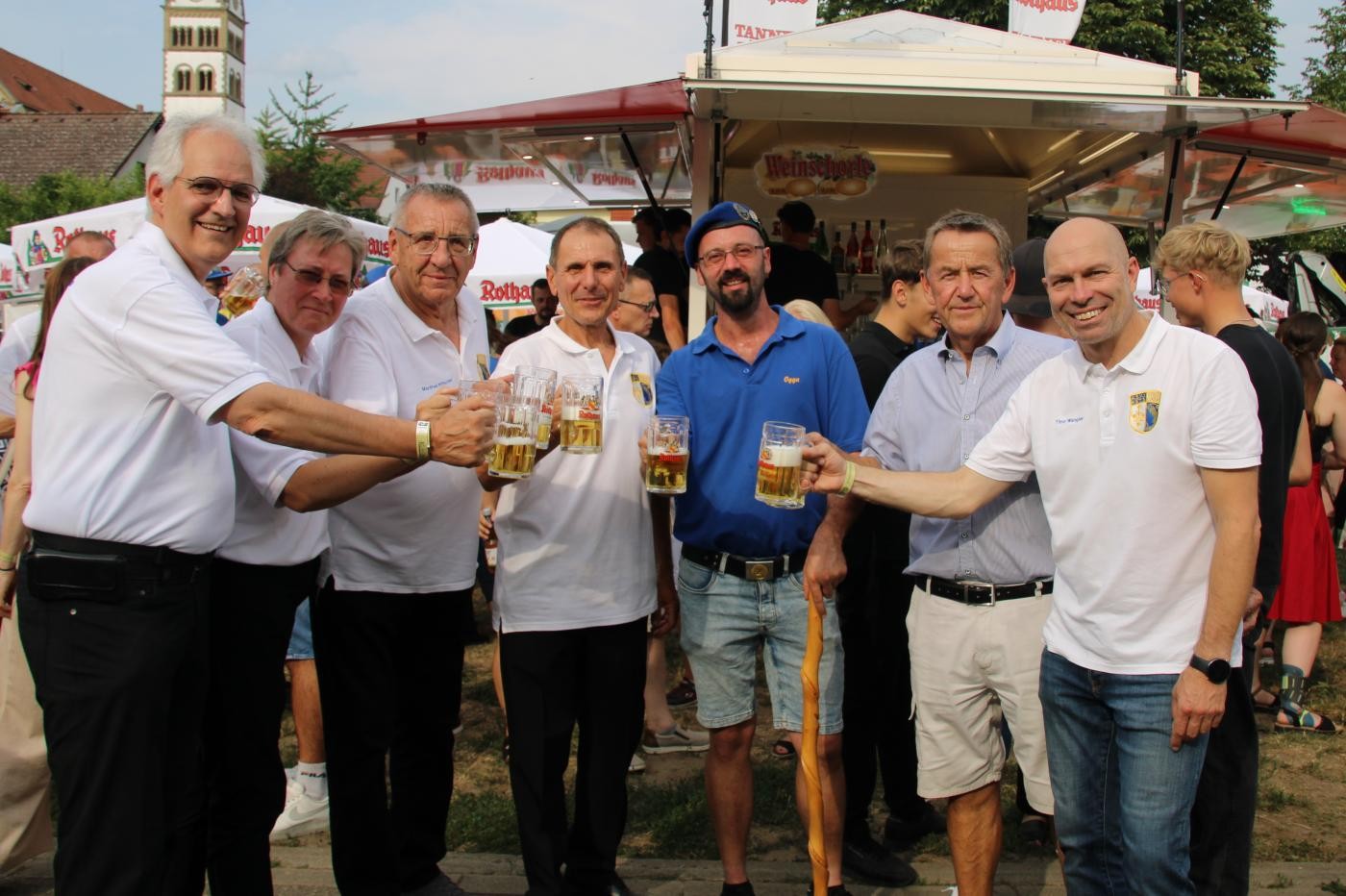 Organisatoren stoßen mit Bierkrügen auf das Fest an